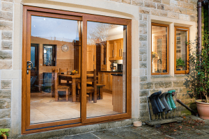 golden oak uPVC sliding patio doors on a stone brick wall