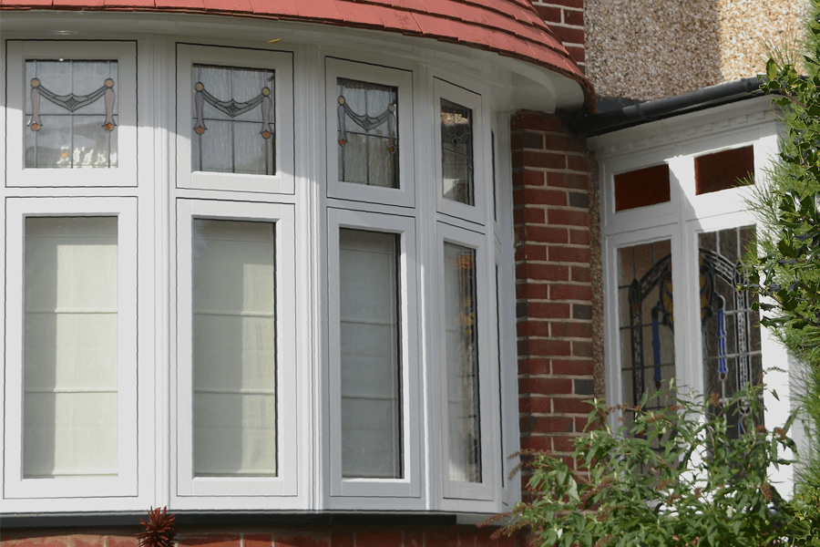 white uPVC flush bow window nest to a stained decorative white uPVC door